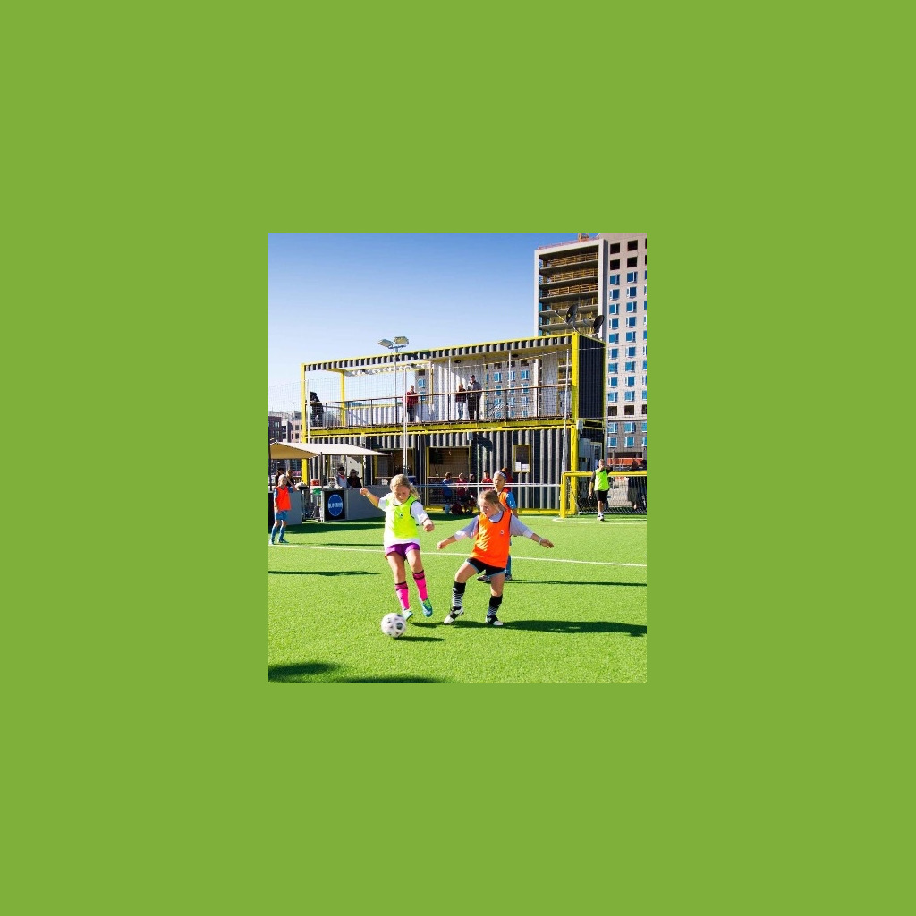 Two young girls playing soccer on a field.