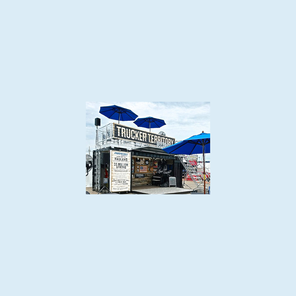 A truck territory stand with blue umbrellas above it.