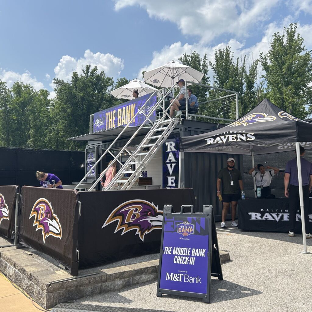 A ravens fan zone with fans and tents.