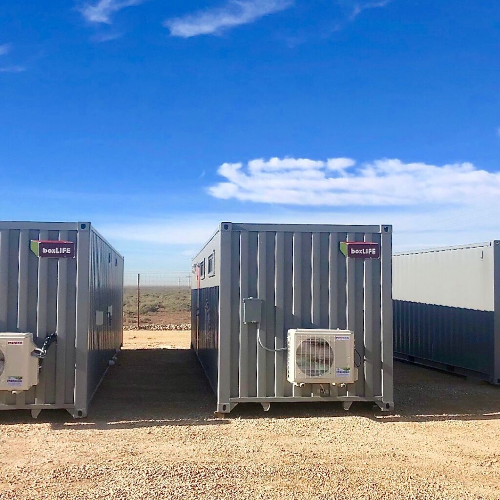 A group of metal containers sitting in the dirt.