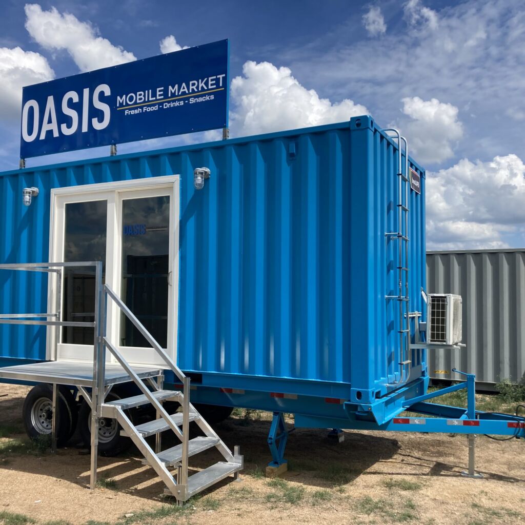 A blue container house with stairs leading to the outside.