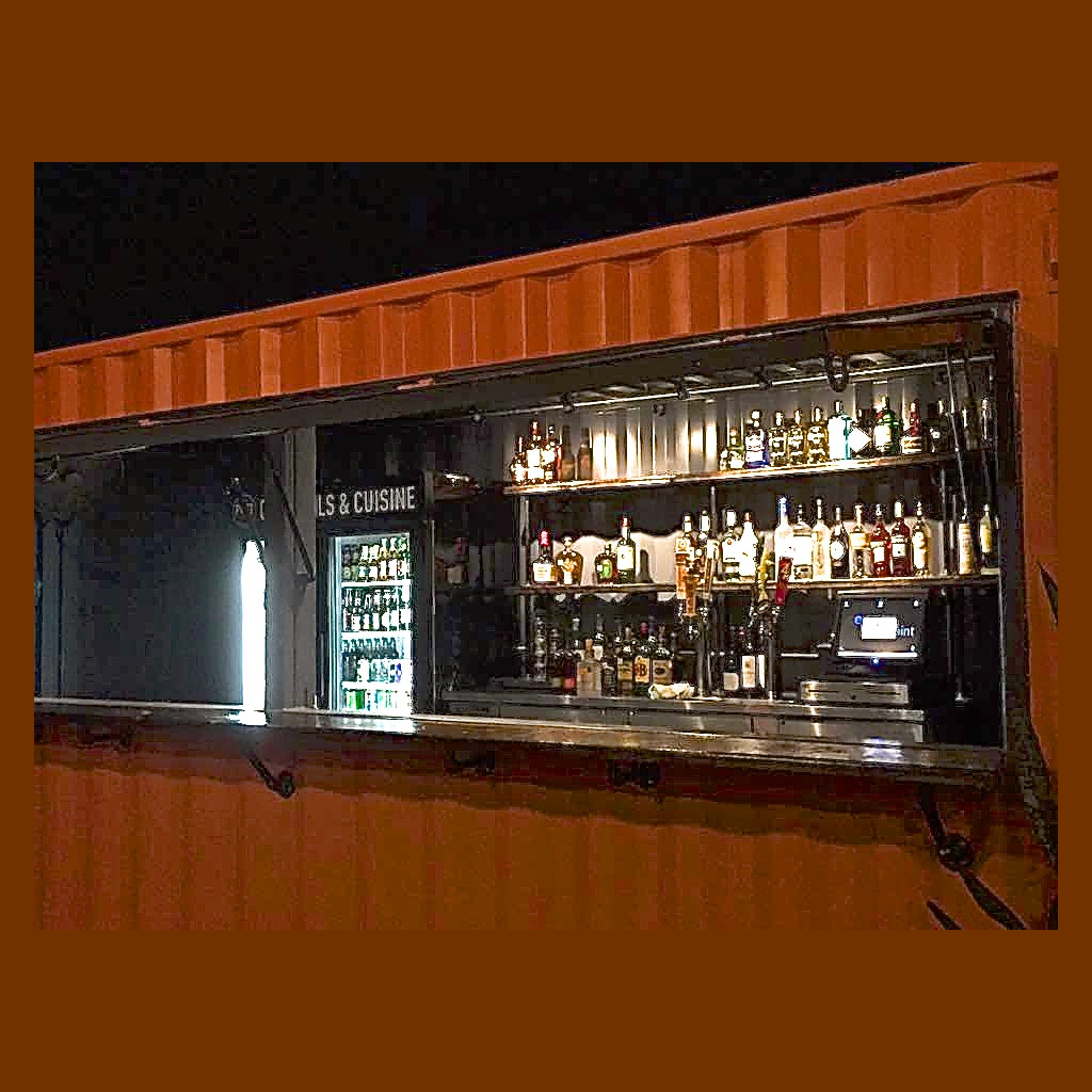 A bar with bottles of alcohol on the counter.