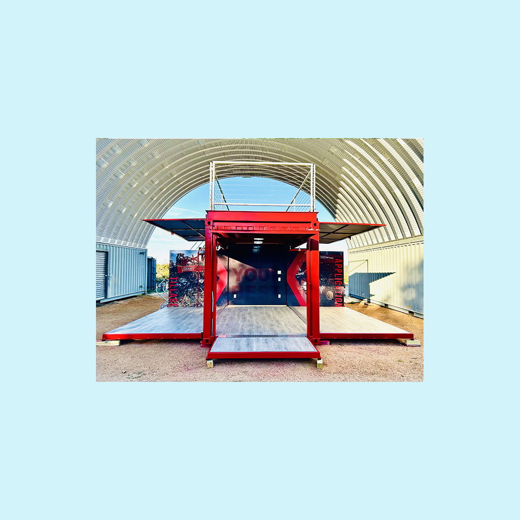 A red container with an open door and a large canopy.
