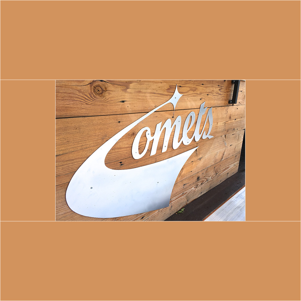 A sign that says comets on the side of a building.