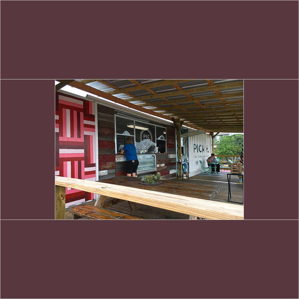 A person standing on the porch of a restaurant.