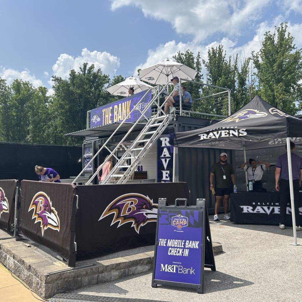 A ravens fan zone with fans and tents.