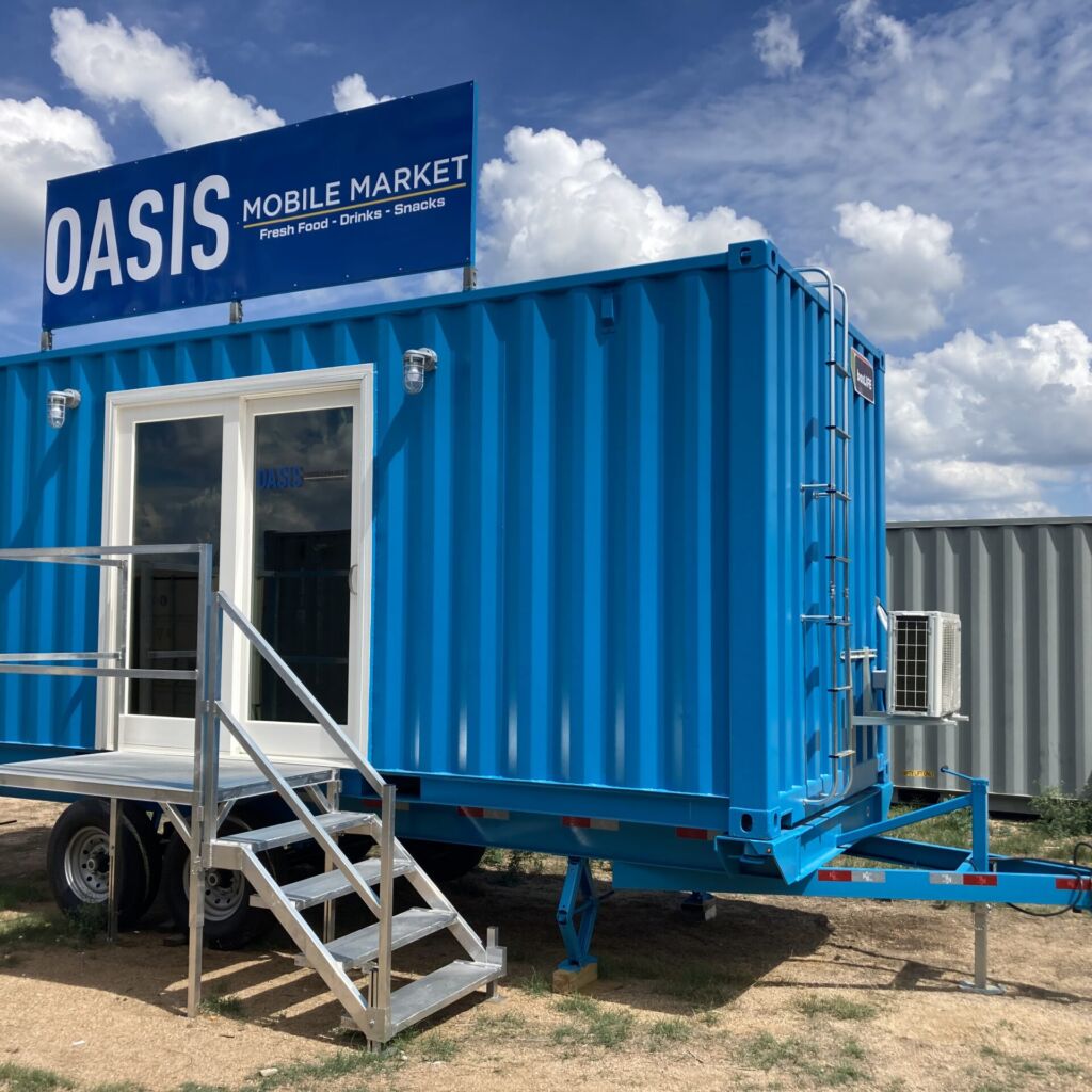 A blue container house with stairs leading to the outside.