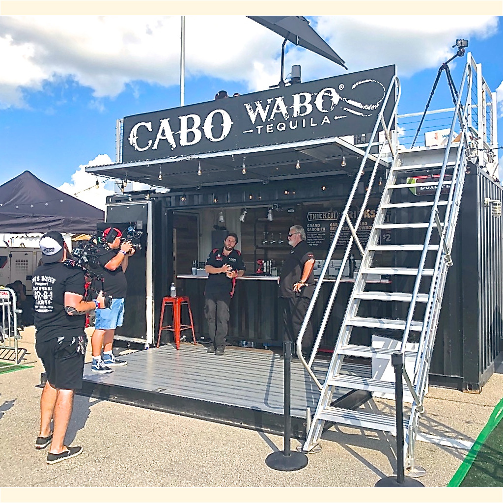 A man standing in front of a bar on top of a stage.