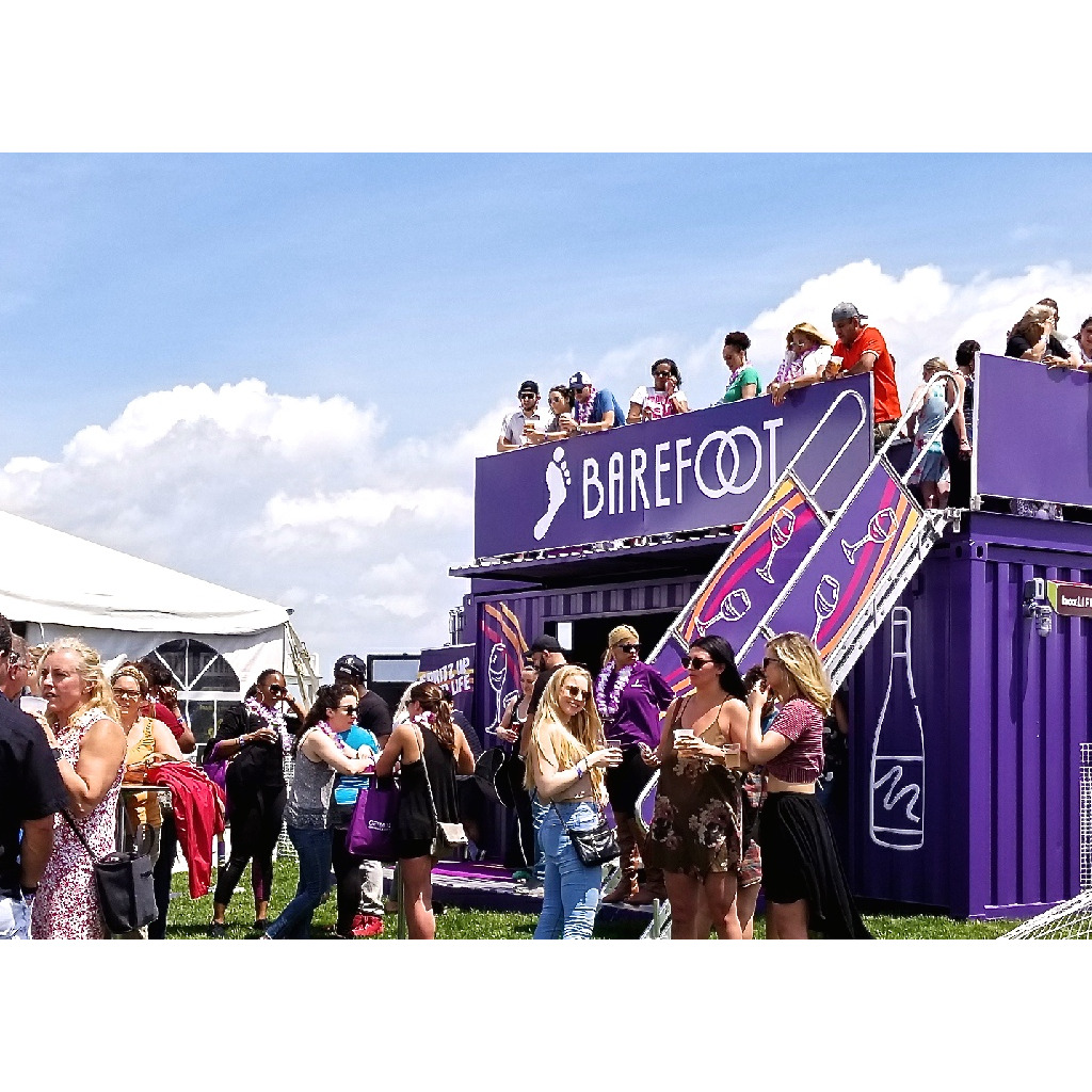 A group of people standing on top of a purple tent.