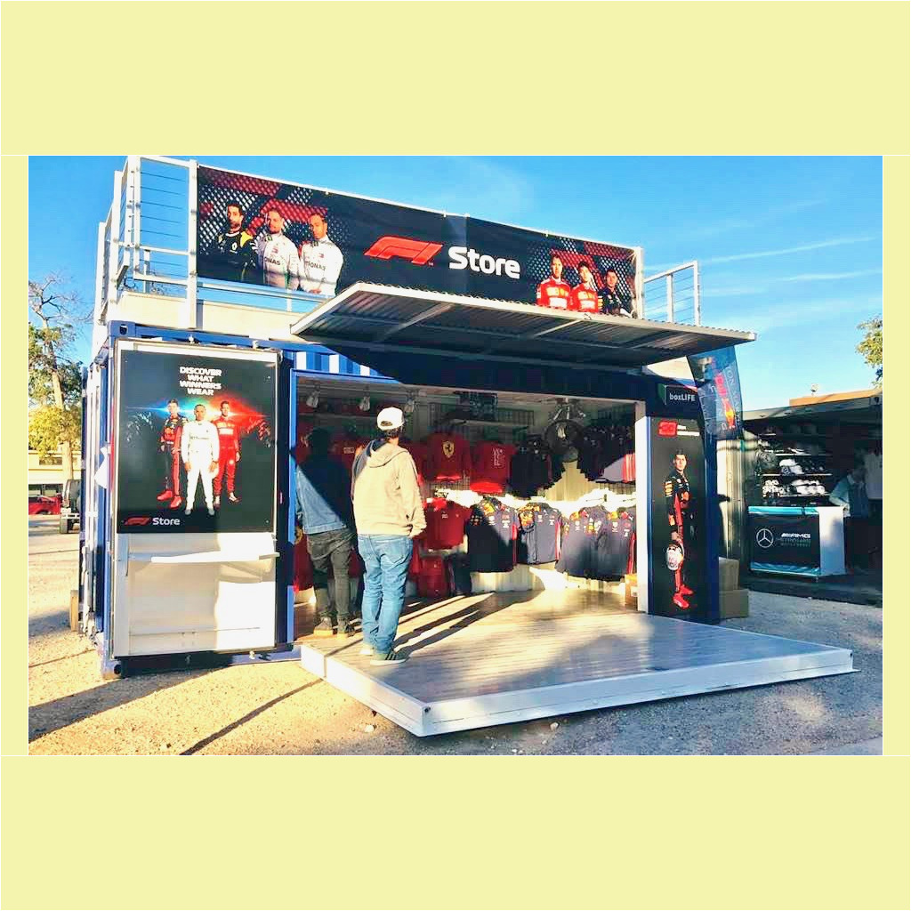 A man standing in front of a store with a large display.