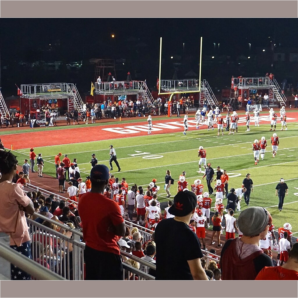A crowd of people standing on top of a field.