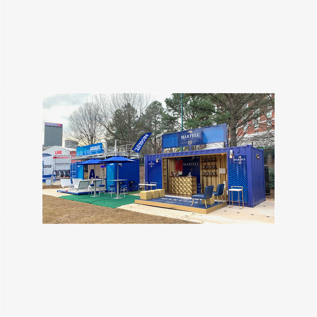 A blue and white tent with tables, chairs and umbrellas.