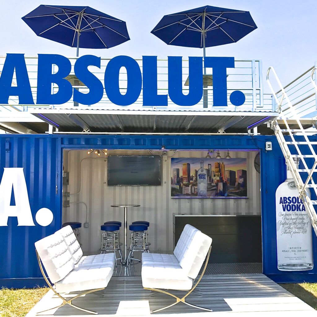 A bar with chairs and umbrellas on top of it.