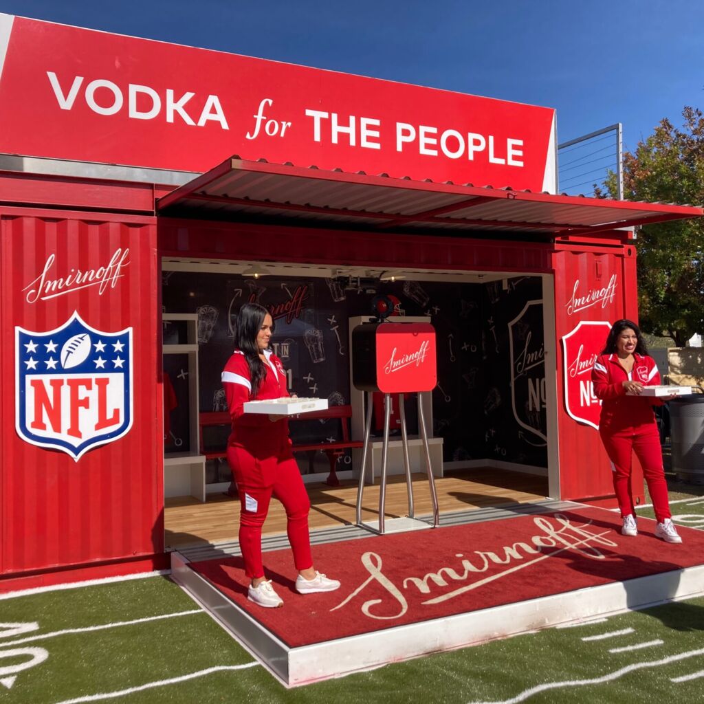 Two people standing in front of a red container.