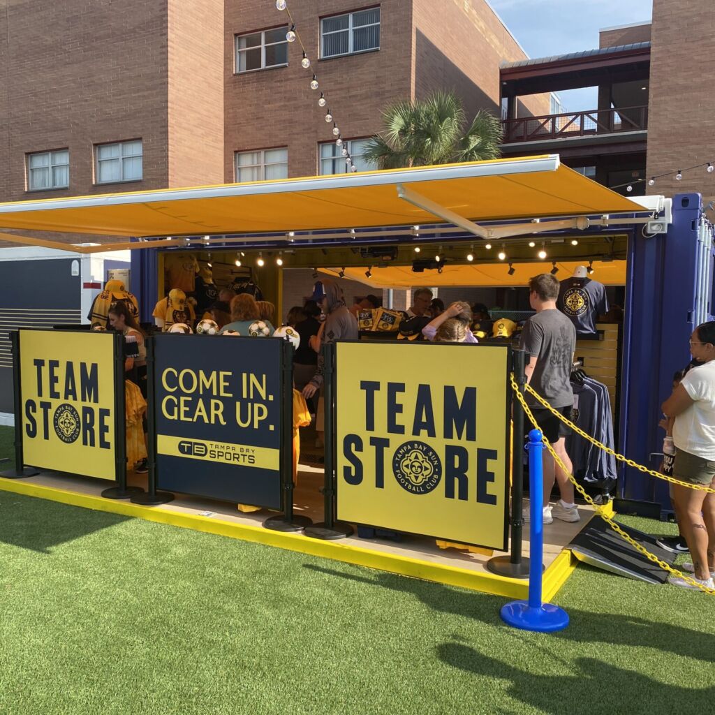 A group of people standing around a team store.
